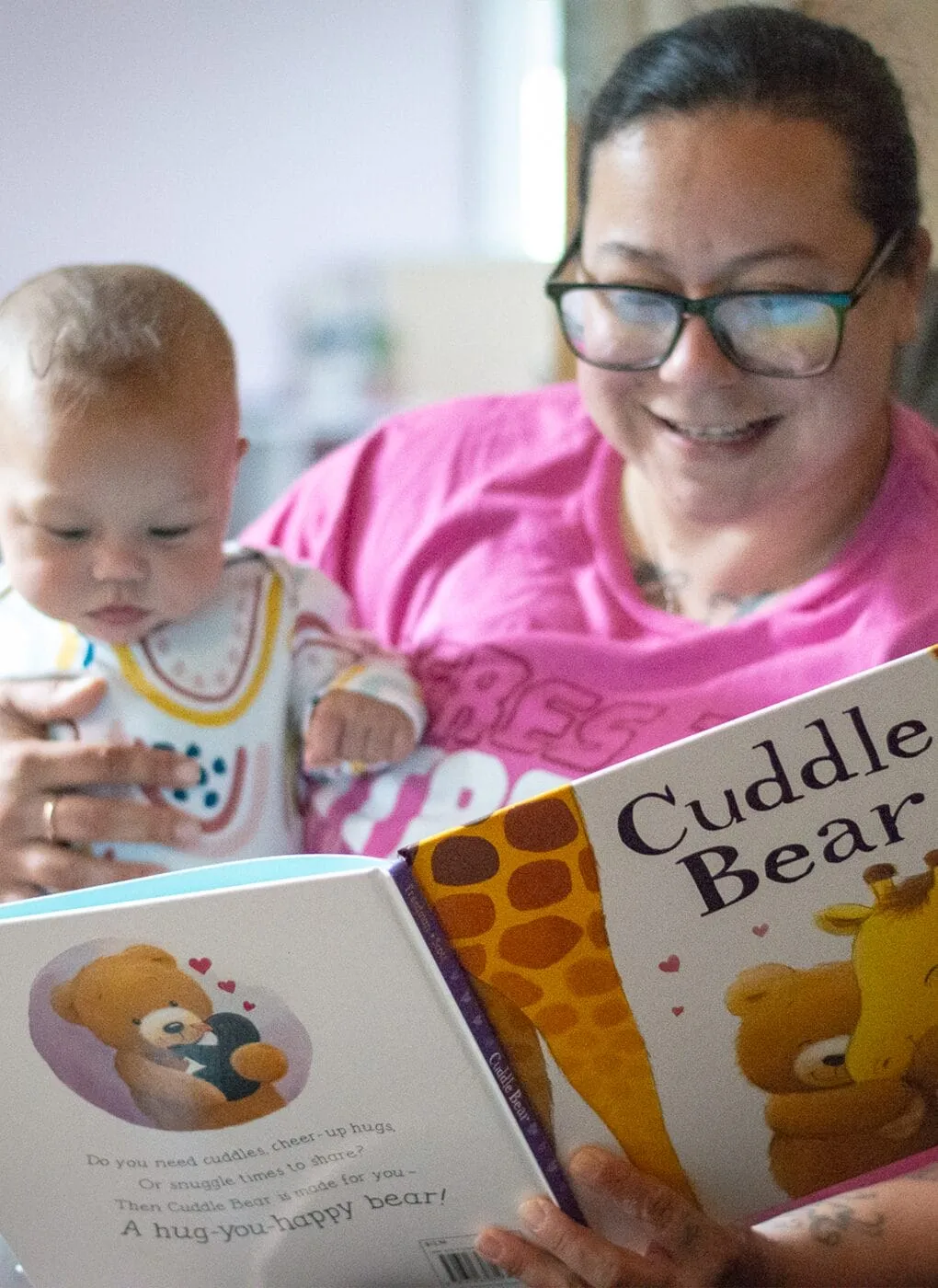 Woman reading the book Cuddle Bear to an infant